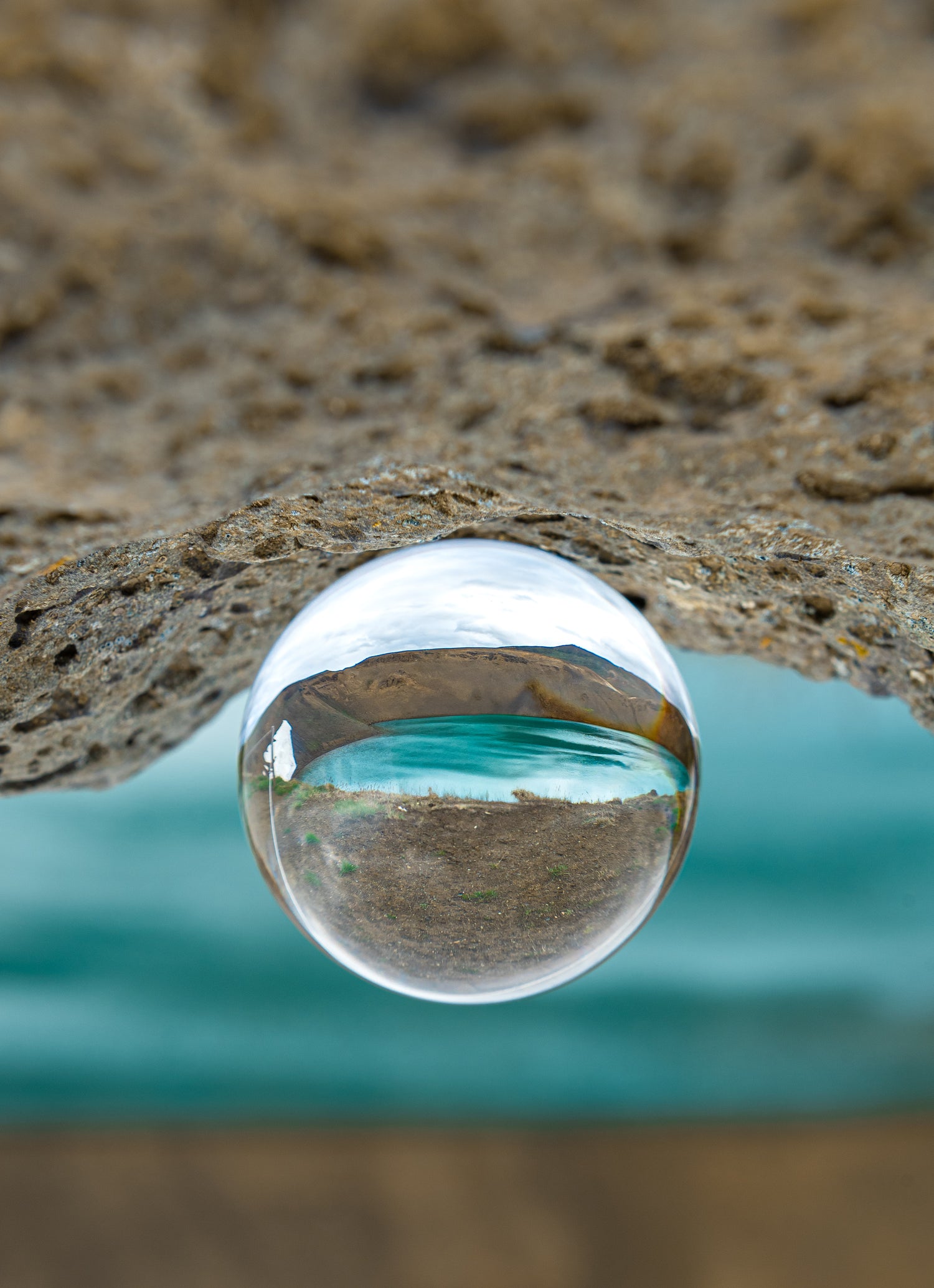 Sphère photo en verre posée sur un rocher reflétant le volcan Islandais Krafla