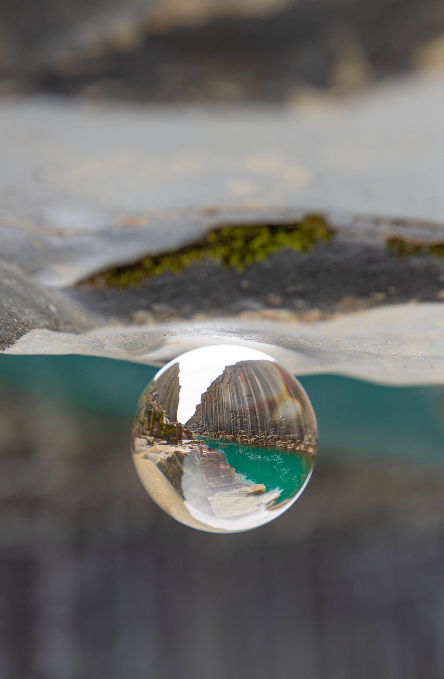 Sphère Photo posée sur un roché reflétant un canyon avec une rivière